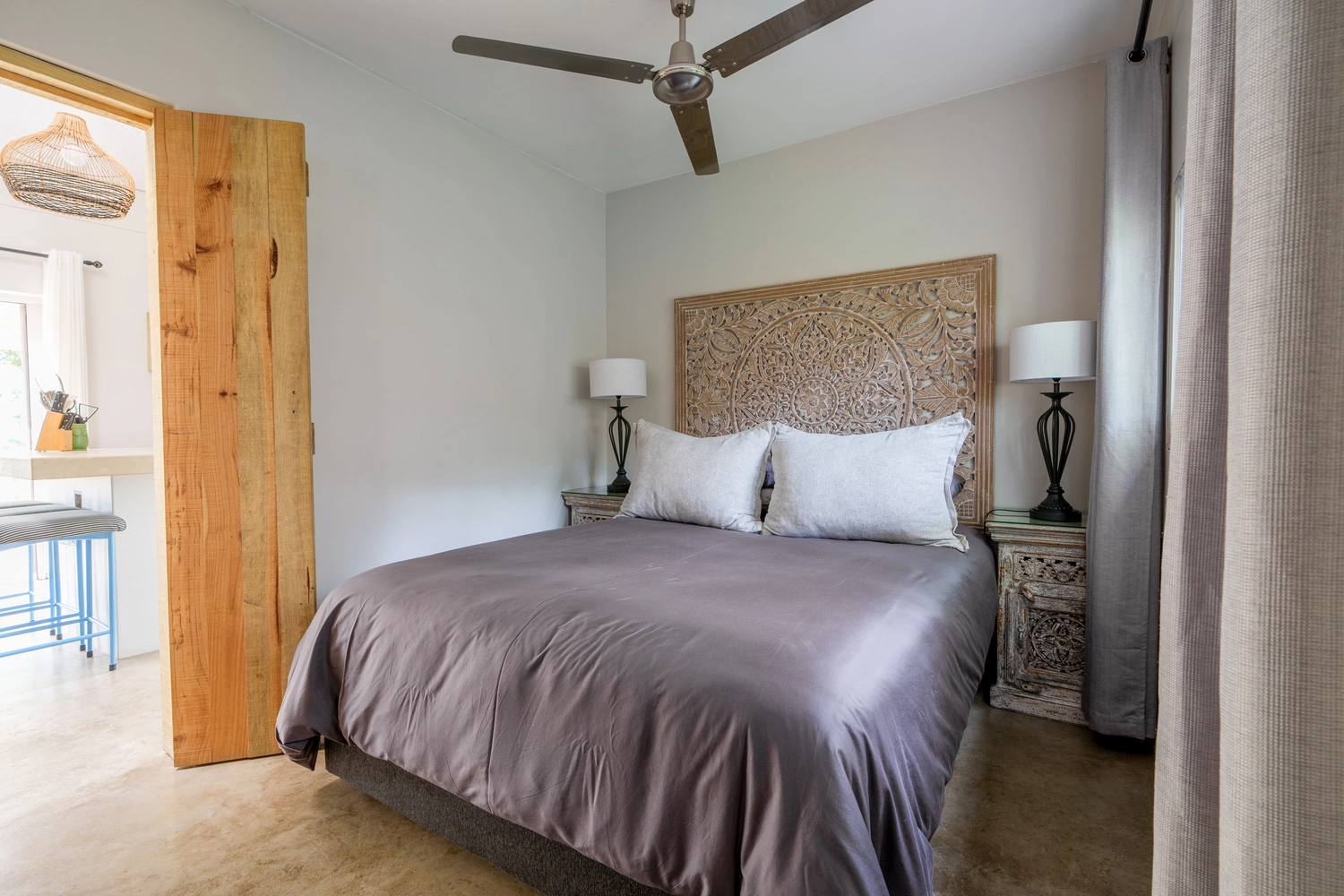 Main bedroom with queen bed and ceiling fan.